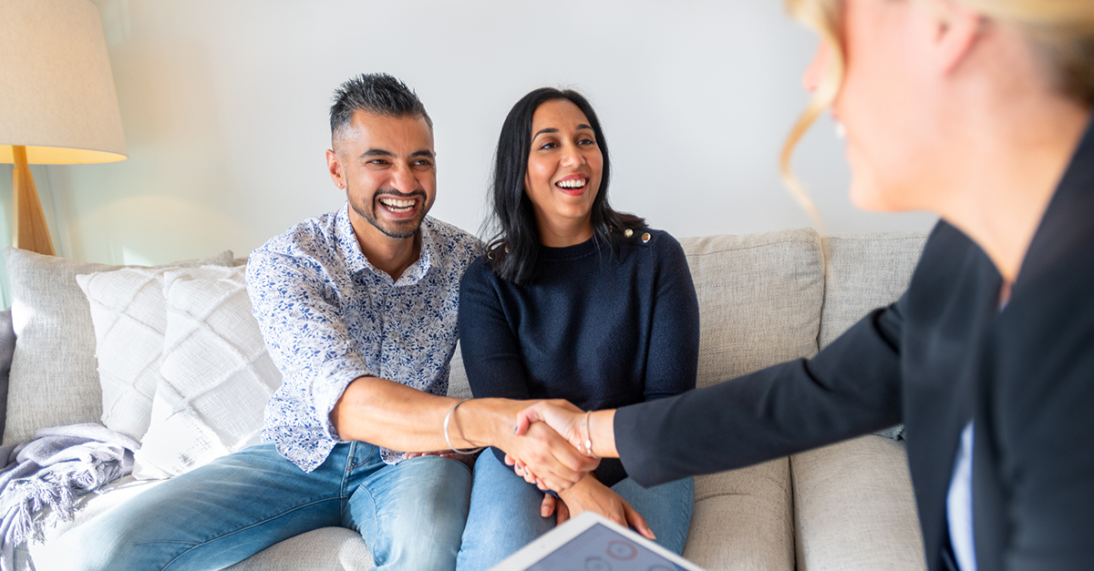 An agent shakes her client's hand